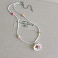 Detalle de collar de cuentas con colgante de concha y amuleto de estrella rosa - Estilo Cuentas de Semilla (27093A)