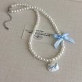 Detalle del collar de perlas con lazo de seda azul claro y colgante de concha blanca - Estilo Perla Artificial (27093B)