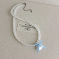 Detalle del collar de perlas con colgante de concha y lazo de cinta azul claro - Estilo Cuentas Esmeriladas (27093C)
