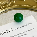 Macro shot of polished dark green agate shoe charm bead on decorative paper board - Dark Green Spherical Round Bead Style (27059-35)