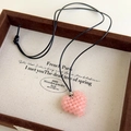 Gros plan d'un collier pendentif cœur en perles roses fait main sur un plateau à bijoux - Rose Orangé