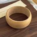 Macro detail of natural wood grain and smooth polished surface on a geometric wide bangle - Flat Thick Wood Style (27120B)