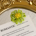 Macro detail of handmade green and yellow beaded flower charm on a decorative card - Tender Green Petal with Bright Yellow Center Style (27059-53)