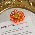 Macro shot of orange beaded flower shoe charm on a romantic vintage display card - Orange Daisy with Bright Yellow Center Style (27059-54)