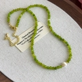 Detailed macro view of green faceted beads and a white freshwater pearl on the necklace - Green Crystal (27143B)