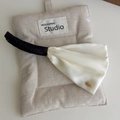 Elegant ivory satin bow banana clip with black velvet trim and gold emblem detail - Solid Cream White