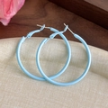 Macro shot of macaron blue matte large hoop earrings on a textured jewelry tray - Blue