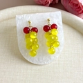 Détail de boucles d'oreilles pendantes en forme de grappe avec perles d'opale rouges et jaunes - Jaune