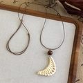 Detail of hand-woven crescent moon pendant with a wooden bead on adjustable brown cord - Crescent Moon Woven Style (27039A)