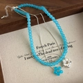 Dettaglio collana a due strati con perle di vetro blu e ciondolo a fiore argento - Blu