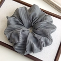 Detail van een zwart-wit geruite oversized haarscrunchie van lichte, doorschijnende stof - Zwart Wit Geblokt