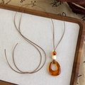 Détail du pendentif goutte en résine ambrée avec corde tressée et perles ethniques - Style Résine en Forme de Goutte (25868A)