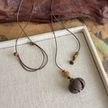 Détail du collier pendentif gland de style chinois avec perles en bois sur plateau - Style Boule de Coton (27174A)