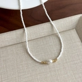Dettaglio di perline colorate e una perla su una collana girocollo in stile francese - Perline Bianche