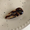 Détail d'une barrette goutte d'eau en acétate écaille de tortue sur une assiette décorative - Marron Multicolore