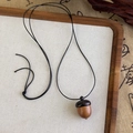 Gros plan détaillé d'un pendentif gland en bois fait main sur un collier de corde noire - Style Gland en Bois Assemblé (26198)