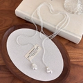 Vista dettagliata della collana a Y vintage francese con perle barocche e design retrò - Bianco
