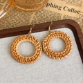 Detail van handgemaakte ronde geweven strooien oorbellen met gouden haken vintage stijl - Ronde rotan oorbellen (26683B)