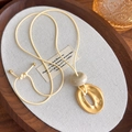 Detail of geometric matte gold oval pendant on a beige adjustable cord necklace - Matte Gold