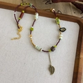 Détail du collier de perles ethnique avec pendentif feuille de bronze sur plateau - Style Feuille Ajourée Bronze (52# 23854B)