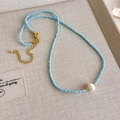 Details einer blauperlenbesetzten Halskette mit weißer Perle und Goldverschluss auf Leinen - Hellblau Kleine Perlen Große Weiße Künstliche Perlenkette (20# 23529D)
