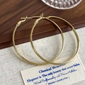 Detailed shot of large golden hoop earrings with textured frost and polished finish - Gold 5cm Diameter