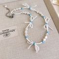 Nahaufnahme der handgefertigten Perlenkette mit weißen Perlen und blauem Perlen-Schleifen-Detail - Weiße Künstliche Perle Blauer Bogen Deko Halskette (37# 25330B)