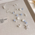 Detail der blauen Perlenkette mit Muscheln und Seestern auf einem beigen Tablett - Himmelblau Perlen Silberner Seestern Anhänger Halskette (39# 26789B)