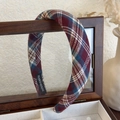 Dettaglio di un cerchietto scozzese fatto a mano in tessuto rosso vino e blu su legno - Quadri Rossi Retro
