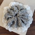 Detailed close-up of floral scrunchie with delicate lace edges on a book cover - White Bottom Black Floral (26452A)