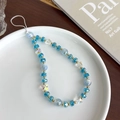 Vue détaillée d'une chaîne de téléphone en perles colorées avec papillon sur assiette - Bleu Iridescent