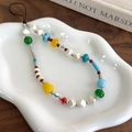 Close-up of colorful beaded phone strap with marble stones and silver metal flower - Yellow and White Beaded Style
