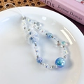 Detailed view of handmade beaded phone strap with blue mesh bow and crystal beads in a dish - Blue Style (26456E)