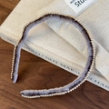 Detailed view of gray velvet headband with pearl trim on a wooden background - Gray