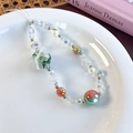 Detailed close-up of rainbow glass beads with floral and mesh bow charm on the strap - Green Style (26456F)