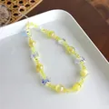 Dettaglio del cinturino per cellulare fatto a mano con perline gialle e farfalle - Giallo Cangiante