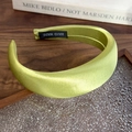 Detalle de la diadema de satén verde hierba con corona alta y etiqueta Hand Made - Estilo Verde Matcha (26475E) / Verde matcha