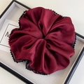 Detail of burgundy satin oversized scrunchie with glitter and black bead trim - Red