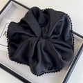 Macro detail of black satin oversized scrunchie with tiny beads and sparkly glitter finish - Black