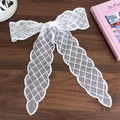 Detail of white lace hair ribbon showing delicate mesh texture and scalloped edges - White Rhombus Style