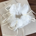 Detailopname van witte organza scrunchie met beige linten en strikjesdetails - Wit lint