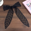 Detailed macro shot of elegant black floral lace ribbon with intricate embroidery on wood - Small Black Flower