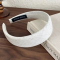 Detalle de diadema de lino beige con etiqueta Hand Made sobre un libro - Patrón de Celosía (26495A) / Beige