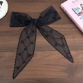 Detailed view of black lace hair ribbon with star embroidery on a wooden surface - Black Star Rhombus Style