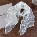 Elegante bufanda de encaje blanco con bordados florales y bordes festoneados sobre madera - Talla única / Blanco