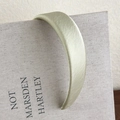Primer plano detallado del elegante acabado satinado y la textura verde claro de la diadema - Verde