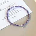 Dettaglio del bracciale di perle viola sfaccettate con perla bianca e ciondolo chiaro - Stile Viola (26521B)