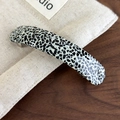 Detail of curved acetate spring hair clip with black and white pebble pattern on linen - Black and White Spots