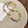 Dettaglio ravvicinato della collana boho con pietre colorate e perle su vassoio di ceramica - Stile Perline Multicolore