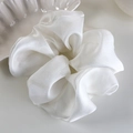 Close-up of oversized white organza scrunchie with elegant pleated texture and pearly luster - White